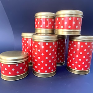 Puede incluir: Conjunto de seis botes de almacenamiento de lunares rojos y blancos con tapas doradas.