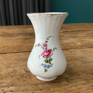 Small white vase with roses.