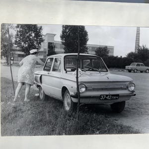 Foto originali in bianco e nero di vecchie auto sovietiche, tra cui una ZAZ Zaporozhec dell'URSS. La foto è stata scattata vicino alla città di Best nel 1975.