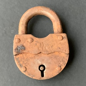 May include: A rusty padlock with a keyhole and the text "53 NEW YORK" on the front.