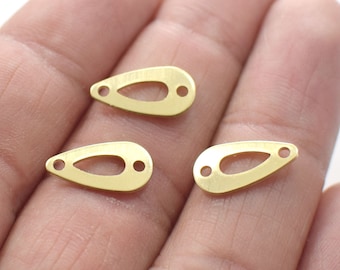 May include: Three gold-colored metal teardrop-shaped charms with a hole on each side. The charms have a cut-out teardrop shape in the center.