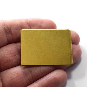 May include: A small, rectangular, gold-colored metal plate.