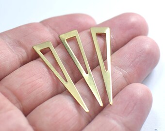 May include: Three gold-colored metal triangle shapes with a cut-out design. The triangles are pointed at the bottom and have a rounded top.