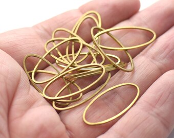 May include: A pile of gold-colored oval-shaped metal rings, likely for jewelry making.