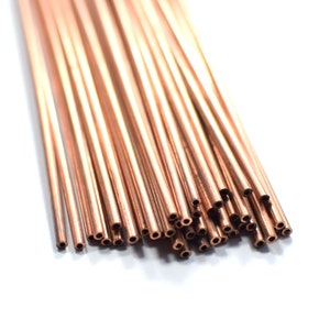 May include: A bundle of copper tubing, arranged in a fan shape, with the ends of the tubes cut at a 45-degree angle.
