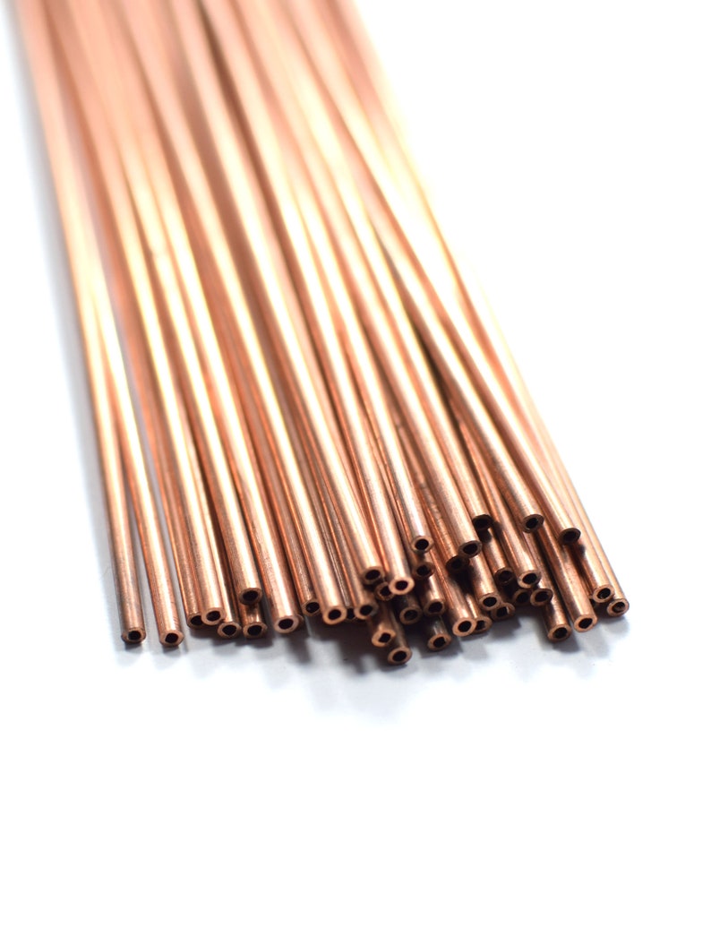 May include: A bundle of copper tubing, arranged in a fan shape, with the ends of the tubes cut at a 45-degree angle.