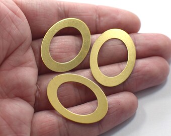 Può includere: Tre anelli ovali in metallo dorato con finitura liscia. Gli anelli hanno un diametro di circa 2,5 cm.