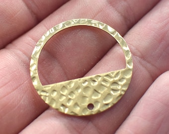 May include: A gold-toned metal circle with a hammered texture and a half-circle cutout. The circle has a small hole at the bottom.
