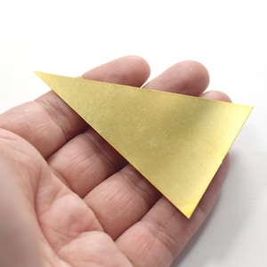 May include: A gold-colored triangle-shaped metal sheet.