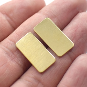 May include: Two small, rectangular brass blanks. The blanks are smooth and have a brushed finish.