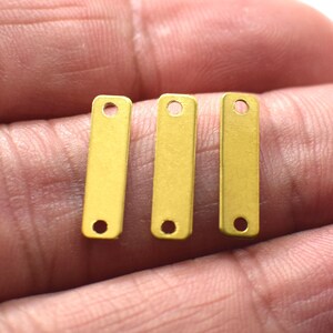 May include: Three gold-colored metal bar connectors with two holes each. The connectors are about 1 inch long and 1/4 inch wide.