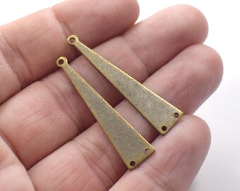 May include: Two antique brass-colored metal earring components. Each component is a long, slender triangle with a hole at the top and two holes at the bottom. The components have a slightly textured surface and a vintage aesthetic.