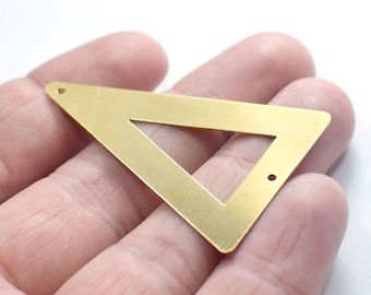 May include: A gold-colored triangle-shaped metal pendant with two holes for attaching a chain or cord. The pendant has a smaller triangle cut out in the center.