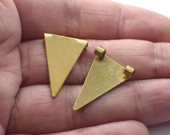 Può includere: Due ciondoli pendenti in metallo a forma triangolare di colore dorato con anelli a salto.