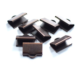 Könnte beinhalten: Zehn antike bronzefarbene Metall-Kordelstopper. Die Stopper haben einen dekorativen, gewellten Rand.
