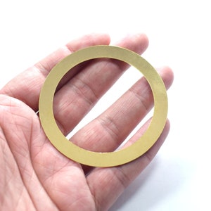 Könnte beinhalten: Ein goldfarbener Metallring mit glatter, polierter Oberfläche. Der Ring ist kreisförmig und hat einen großen Innendurchmesser.