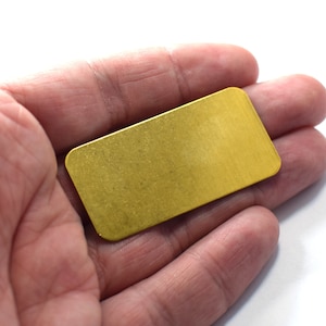 Pode incluir: Uma pequena barra de metal retangular de cor dourada.