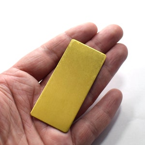Pode incluir: Uma peça retangular de metal de cor dourada.