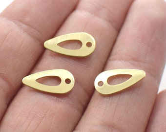 May include: Three small, gold-colored teardrop-shaped metal charms. Each charm has a teardrop-shaped cutout in the center and a small hole at the top for stringing. These charms are ideal for jewelry making.