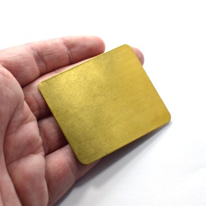 May include: A small, rectangular brass plate with a brushed finish.