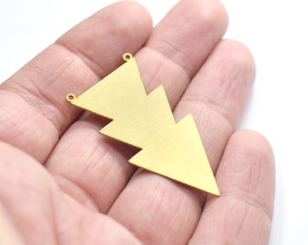 Può includere: Un ciondolo in metallo color oro a forma di albero di Natale stilizzato a tre punte. Il ciondolo ha due piccoli fori nella parte superiore per attaccare una catena o un cordino.