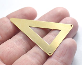 May include: A gold-colored metal triangle with a smaller triangle cut out of the center. The triangle has two small holes on the top and bottom edges.
