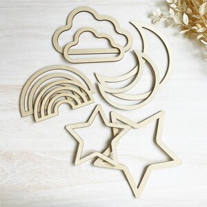 May include: Set of wooden cutout shapes including a rainbow, clouds, stars, and moons. The shapes are unfinished and ready to be painted or stained.