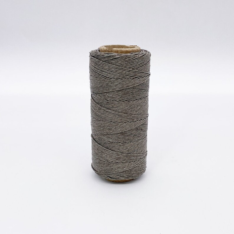 May include: A spool of gray linen thread.