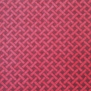 Könnte beinhalten: Roter Stoff mit einem sich wiederholenden geometrischen Muster aus kleinen Quadraten und Rauten.