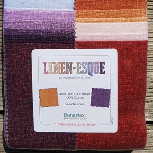 May include: A fabric bundle with a variety of colored strips, including shades of blue, purple, orange, and brown. The label reads "LINEN-ESQUE" and includes the dimensions of the strips: (40) 6.35cm x 106.68cm strips, 100% cotton.