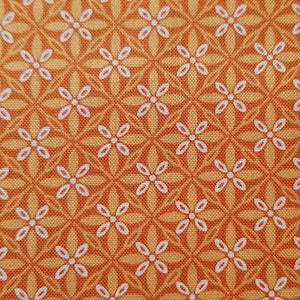May include: Orange fabric with a white floral pattern. The pattern is a repeating design of small white flowers with a circle in the centre.