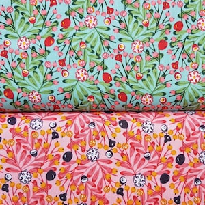 Könnte beinhalten: Zwei Stoffmuster mit Blumenmustern. Das obere Muster hat einen hellblauen Hintergrund mit grünen Blättern, rosa Blüten und roten Beeren. Das untere Muster hat einen rosa Hintergrund mit orangefarbenen Blättern, weißen Blüten und schwarzen Beeren.