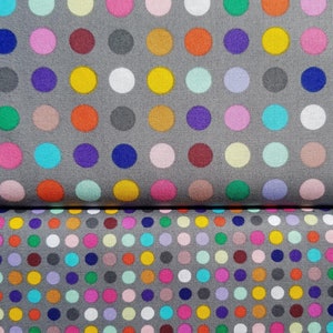 Könnte beinhalten: Zwei Stoffstücke mit grauem Hintergrund und einem sich wiederholenden Muster aus bunten Punkten.
