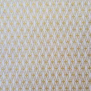 May include: White fabric with a gold geometric pattern. The pattern is made up of small diamonds and squares.