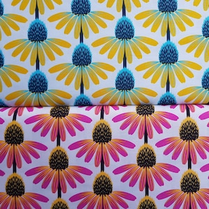 Op de afbeelding: Twee stofstalen met een herhalend patroon van gestileerde bloemen. De bovenste staal heeft gele bloemen met blauwe centra op een witte achtergrond. De onderste staal heeft roze bloemen met zwarte centra op een witte achtergrond.