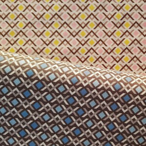 May include: Two fabric swatches with geometric patterns. The top swatch has a brown, pink, and yellow diamond pattern. The bottom swatch has a brown, blue, and white diamond pattern.