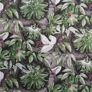 May include: A gray fabric with a repeating pattern of green passionflower blossoms and leaves. The fabric has a subtle texture and a vintage aesthetic.