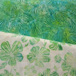 Pode incluir: Duas peças de tecido com padrão verde e branco. O tecido superior tem um padrão floral maior e mais abstrato. O tecido inferior tem um padrão floral menor e mais detalhado.