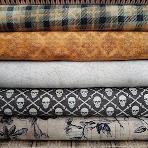 Könnte beinhalten: Ein Stapel von sechs Stoffmustern mit verschiedenen Halloween-Motiven, darunter ein schwarz-weißes Rautenmuster, ein grün-schwarzes Karomuster, ein braun-oranges Damastmuster, ein weißes Spinnennetzmuster, ein schwarz-weißes Totenkopf- und Knochenmuster und ein braun-weißes Blumenmuster.