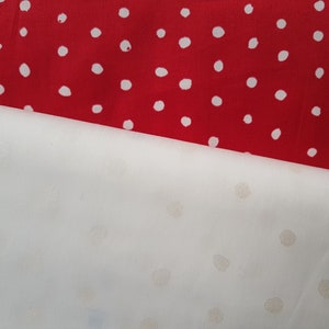 Peut inclure: Deux morceaux de tissu avec des pois blancs sur fond rouge et blanc.