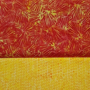 Può includere: Due campioni di tessuto, uno con un motivo floreale rosso e giallo e l'altro con uno sfondo giallo e piccoli cerchi arancioni.