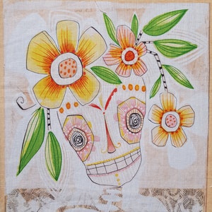 Könnte beinhalten: Eine skurrile Illustration eines lächelnden Schädels mit Blumen und Blättern. Der Schädel hat rosa und weiße Augen, eine rote Nase und ein zahniges Grinsen. Die Blumen sind gelb, orange und rosa.