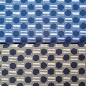May include: Two fabric swatches with a repeating pattern of white circles with white horizontal lines inside, on a blue background and a green background.