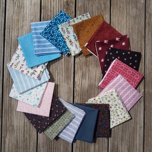 Puede incluir: Una colección de 15 cuadrados de tela con varios patrones y colores, dispuestos en círculo sobre una superficie de madera. Las telas presentan diseños florales, geométricos y a rayas en tonos de azul, rojo, rosa, verde y marrón.