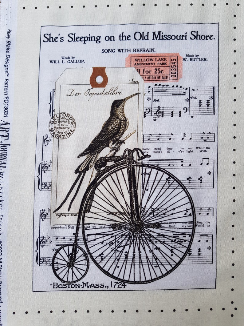 Op de afbeelding: Cr&egrave;mekleurige stof met een vintage ontwerp. Het toont bladmuziek, een kolibrie op een hoge bi en de tekst "She's Sleeping on the Old Missouri Shore." Bevat een kaartje van Willow Lake Amusement Park.