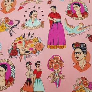 May include: Pink fabric featuring illustrations of Frida Kahlo, roses, paintbrushes, and text in Spanish. The design includes tattoo-style elements like banners and hearts, creating a vibrant and artistic pattern.
