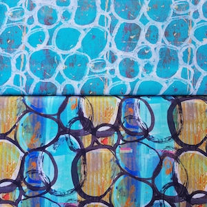 Könnte beinhalten: Zwei Stoffstücke mit blauem Hintergrund und einem Muster aus weißen und schwarzen Kreisen. Der obere Stoff hat ein abstrakteres Muster aus weißen Kreisen auf blauem Hintergrund. Der untere Stoff hat ein definierteres Muster aus schwarzen Kreisen auf blauem Hintergrund.