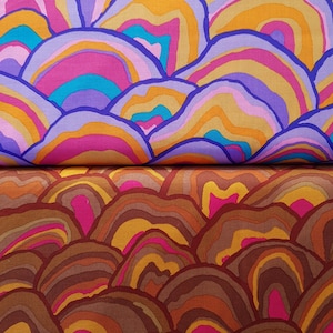 Op de afbeelding: Een stof met een herhalend patroon van overlappende, abstracte vormen in verschillende kleuren, die lijken op heuvels of golven. De vormen zijn in tinten roze, paars, blauw, oranje en geel. De stof is verdeeld in twee delen, waarbij het bovenste deel een lichter kleurenpalet heeft en het onderste deel een donkerder kleurenpalet.