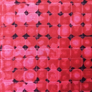 Puede incluir: Tela roja con un patrón de diamantes negros y una superposición de cuadrícula blanca. La tela tiene un efecto tie-dye.