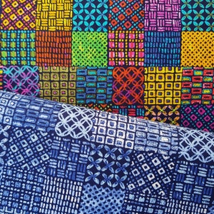 Könnte beinhalten: Zwei Stoffstücke mit geometrischen Mustern. Der obere Stoff ist schwarz mit bunten Quadraten mit verschiedenen geometrischen Mustern. Der untere Stoff ist dunkelblau mit weißen geometrischen Mustern.